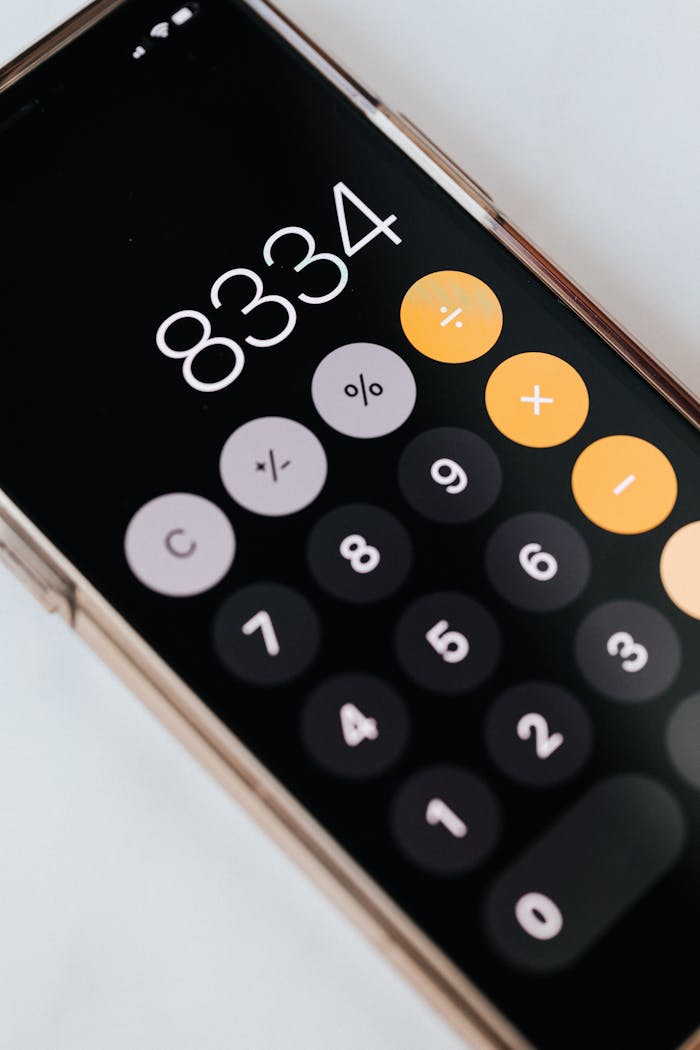 Close-up of a smartphone displaying a calculator app with numbers and symbols.